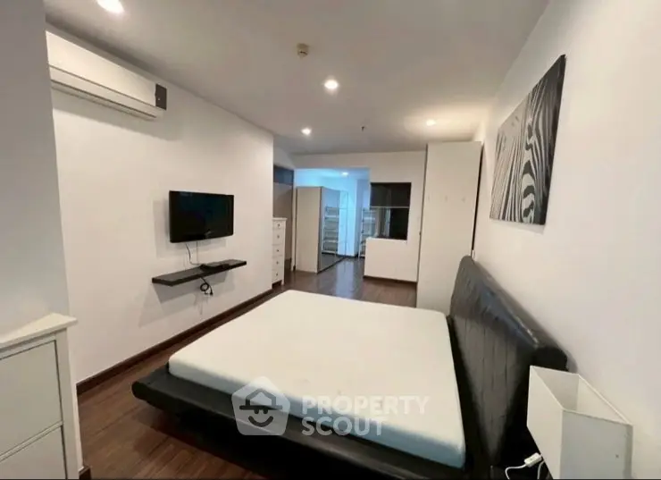Modern bedroom with sleek design, featuring a mounted TV and air conditioning for comfort.