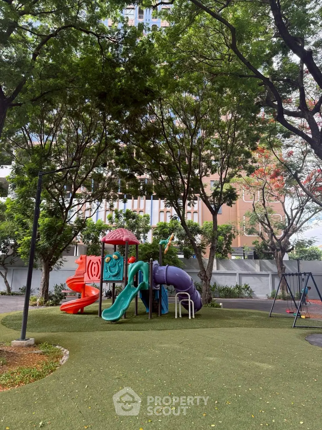 Charming residential playground surrounded by lush greenery, perfect for family-friendly living.