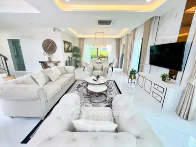 Luxurious open-plan living room with elegant decor and modern furnishings, featuring a spacious seating area and large windows.
