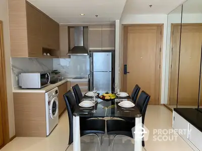 Modern kitchen with dining area, featuring sleek appliances and stylish furniture.