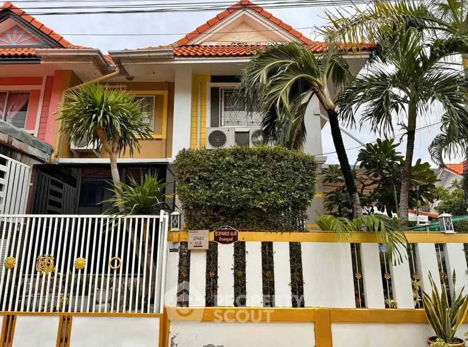 Charming townhouse with vibrant exterior and lush greenery in a serene neighborhood.