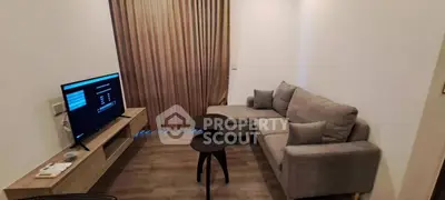 Cozy living room with modern gray sofa and flat-screen TV, ideal for relaxation.