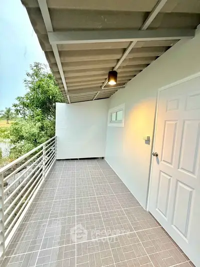 Spacious balcony with modern tile flooring and scenic view, perfect for relaxation.