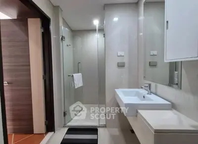 Modern bathroom with glass shower and sleek fixtures in a contemporary apartment.