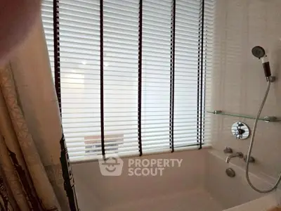 Modern bathroom with bathtub and sleek blinds, perfect for relaxation.