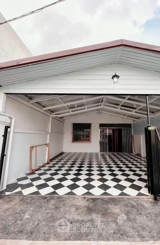 Charming covered parking area with checkered flooring and modern lighting.