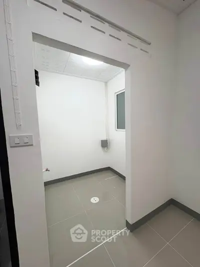 Minimalist storage room with sleek tile flooring and modern lighting.