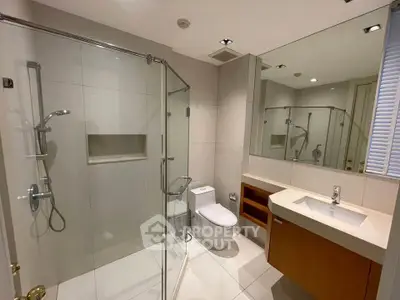 Modern bathroom with glass shower and sleek fixtures in a contemporary home.