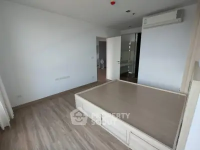 Spacious bedroom with modern flooring and built-in air conditioning unit.