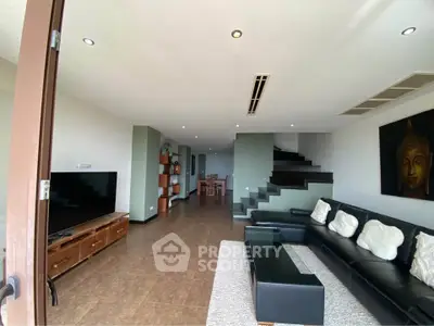 Spacious modern living room with sleek black sofa and stylish decor