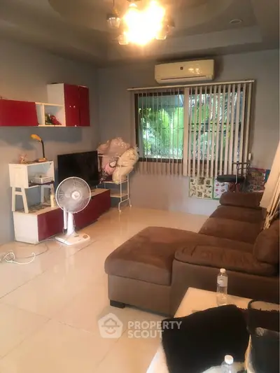 Cozy living room with sectional sofa, TV, and air conditioning, perfect for relaxation.