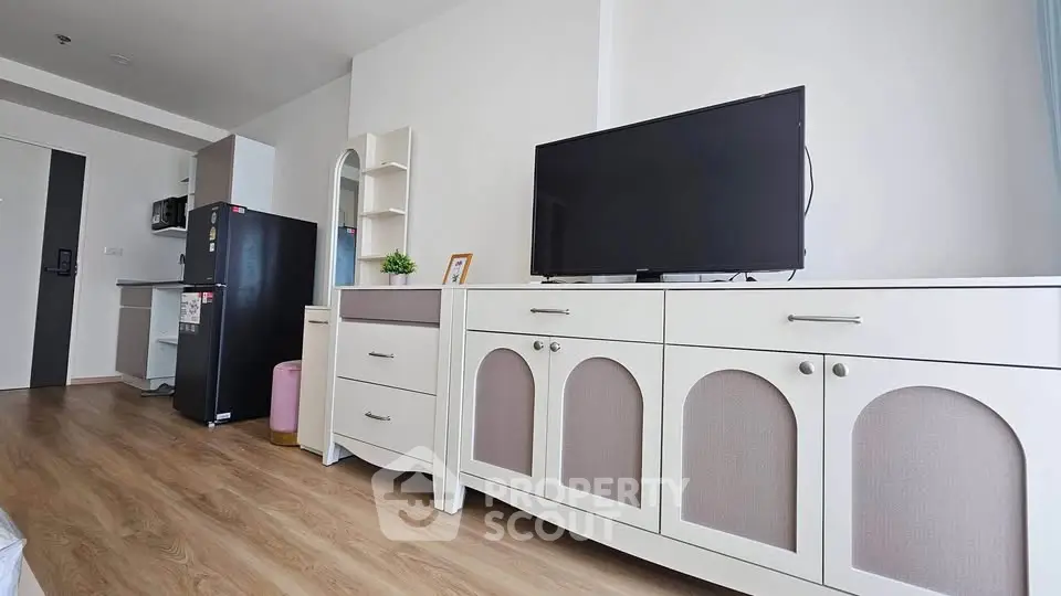 Modern living room with stylish furniture and sleek appliances in a bright, airy apartment.