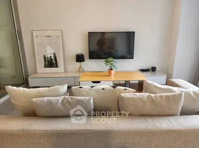 Modern living room with cozy sofa and wall-mounted TV, perfect for relaxation.