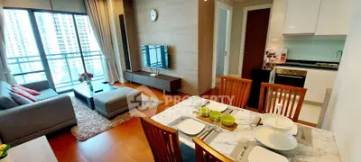 Modern open-plan living room with dining area and kitchen in a high-rise apartment.