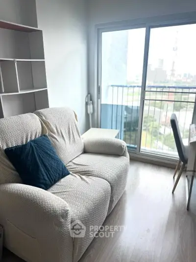 Cozy living room with a comfy sofa and a view of the city from the balcony.