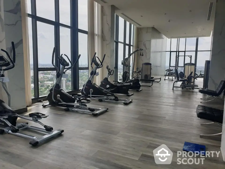 Spacious gym with panoramic city views and modern fitness equipment