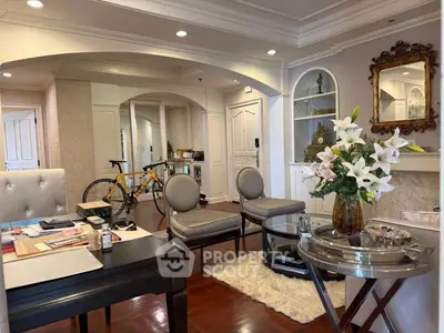 Elegant living room with classic decor and hardwood floors, featuring a cozy seating area and stylish archways.