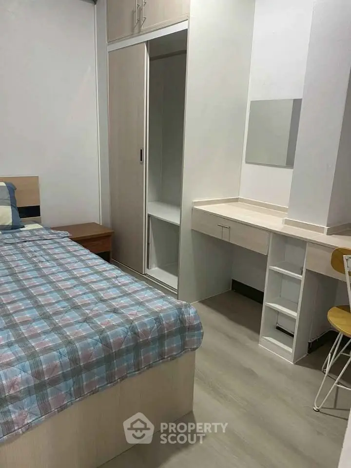 Cozy bedroom with modern furniture and ample storage space, perfect for comfortable living.