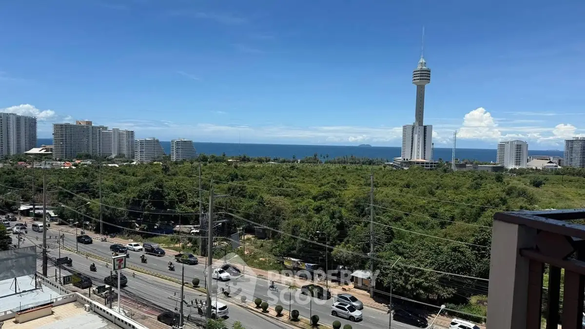 Stunning cityscape view with ocean horizon and iconic tower, perfect for urban living enthusiasts.