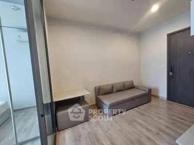 Modern living room with sleek gray sofa and minimalist decor in a stylish apartment.