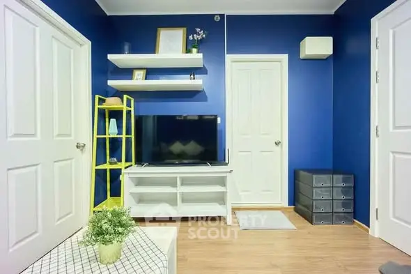 Stylish living room with blue walls, modern TV stand, and decorative shelves.