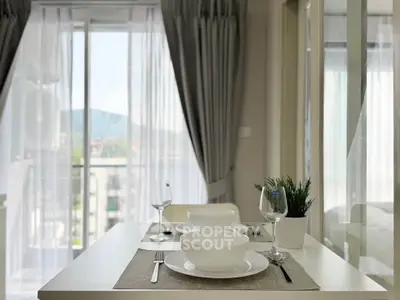Modern dining area with elegant table setting and balcony view in a stylish apartment.