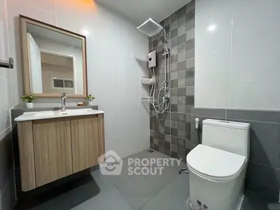 Modern bathroom with sleek fixtures and stylish tile design, featuring a spacious shower area and elegant vanity.