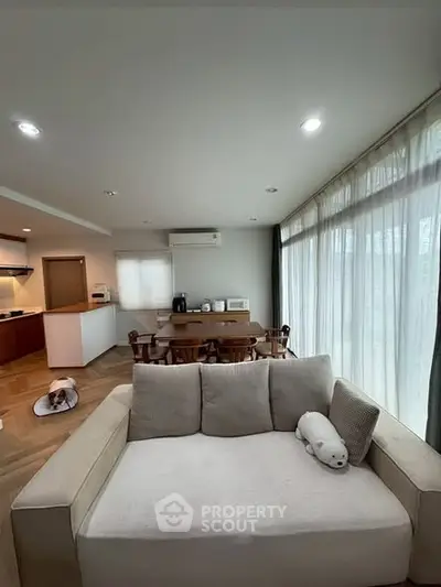 Spacious living room with modern decor and large windows for natural light.