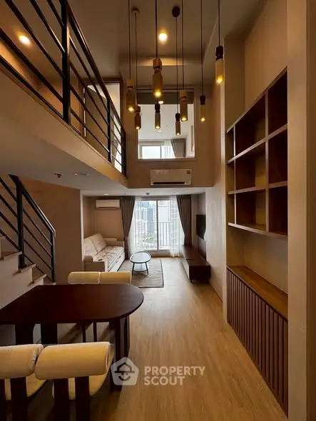 Modern duplex living room with high ceiling and stylish lighting in a contemporary apartment.