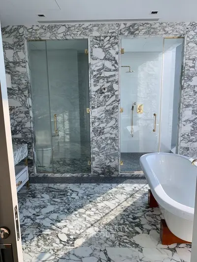 Luxurious marble bathroom with glass shower and freestanding bathtub