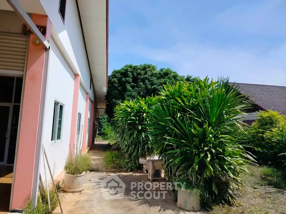 Charming exterior view of a property with lush greenery and clear blue sky.