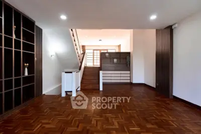 Spacious modern living room with elegant wooden flooring and built-in shelving