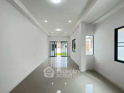 Spacious modern living room with large windows and glossy tiled floors