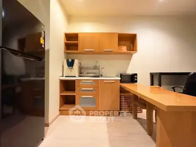 Cozy kitchen with wooden cabinets and modern appliances, perfect for compact living spaces.