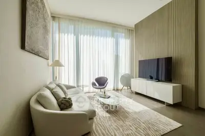 Elegant modern living room with large windows, stylish furniture, and natural light.