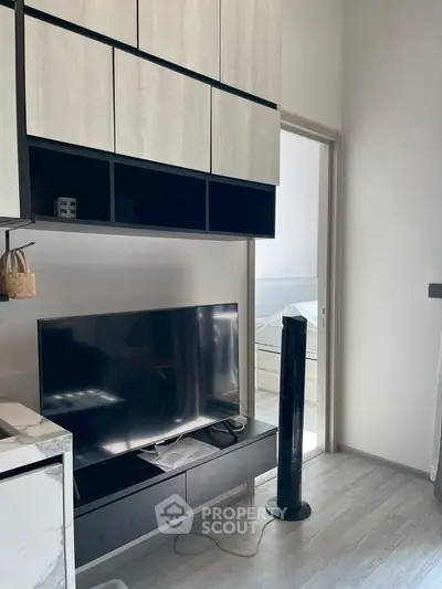 Modern living room with sleek TV setup and stylish storage cabinets.
