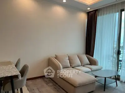 Modern living room with cozy sofa and elegant dining area, featuring large windows for natural light.