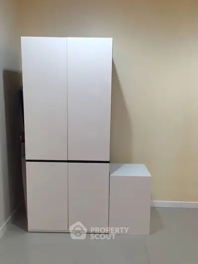 Modern minimalist white storage cabinet in a sleek interior setting.