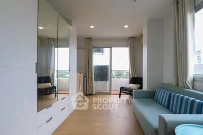 Bright living room with modern furniture and large windows offering a serene view.