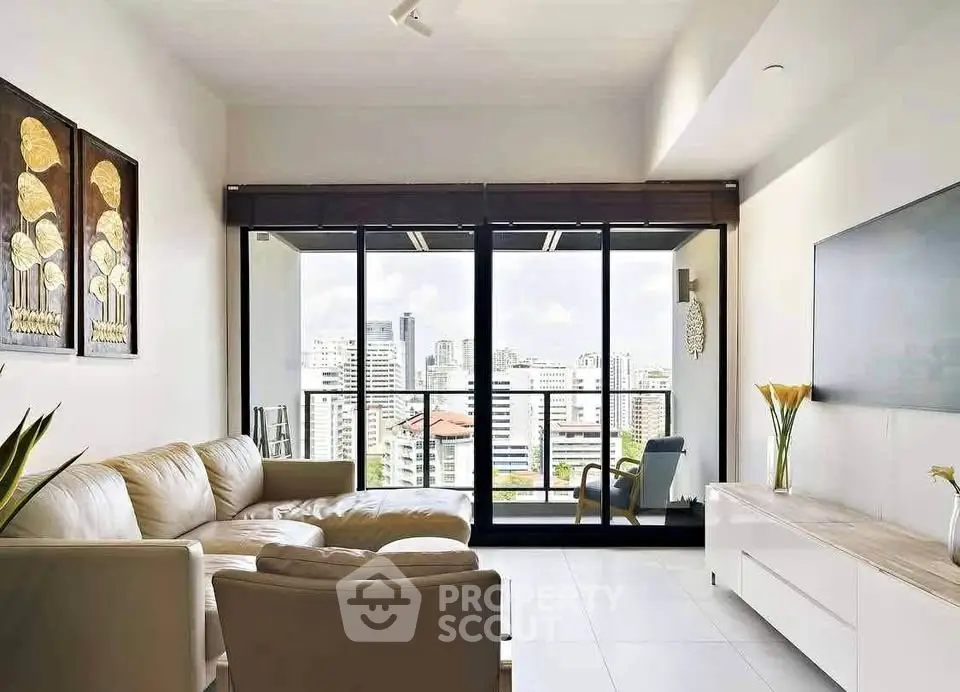 Spacious living room with modern decor and stunning city view from large windows.