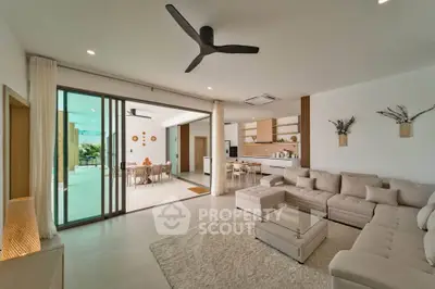Spacious modern living room with open layout and stylish decor, leading to a bright outdoor patio.