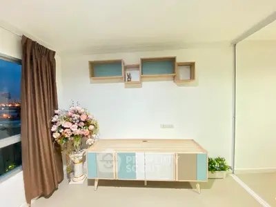 Modern minimalist living room with sleek white storage cabinets, warm lighting, and a large window offering a city view, perfect for urban living.