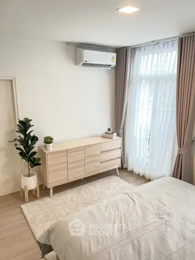 Bright and airy bedroom with modern decor and large window for natural light.