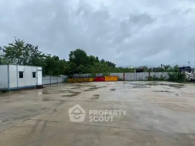 Spacious outdoor industrial area with storage containers and office unit