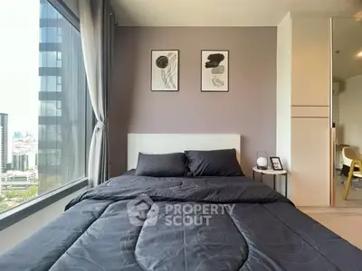 Modern bedroom with large window offering city view, stylish decor, and cozy bedding.