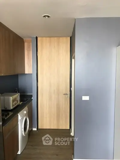 Modern kitchen with washing machine and microwave in compact space