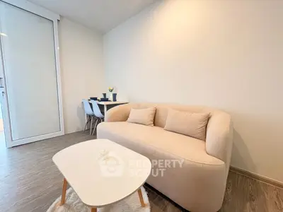 Modern living room with stylish beige sofa and sleek dining area, perfect for urban living.