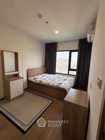 Modern bedroom with city view, featuring cozy wooden furniture and large window.