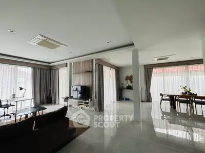 Spacious open-plan living and dining area with modern decor and large windows.