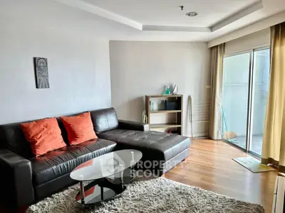 Spacious living room with modern decor and large glass doors leading to a balcony.